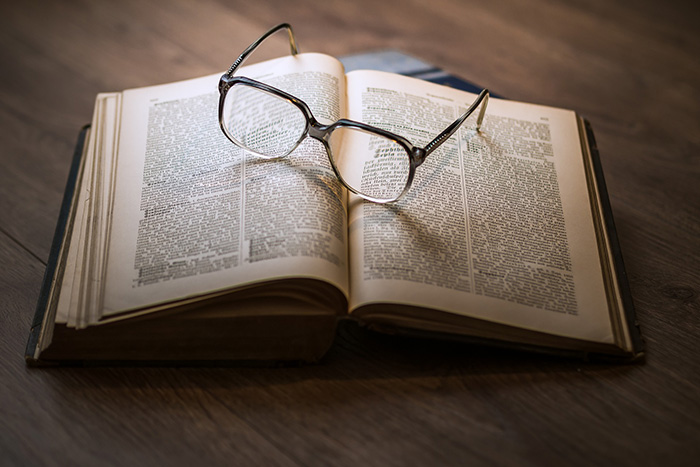 Livro aberto com óculos em cima